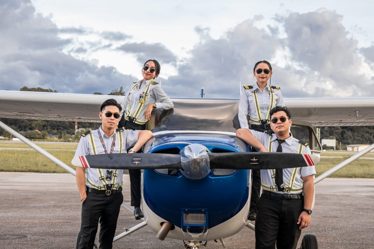 Layang Layang Flying Academy student pilots standing with a training aeroplane
